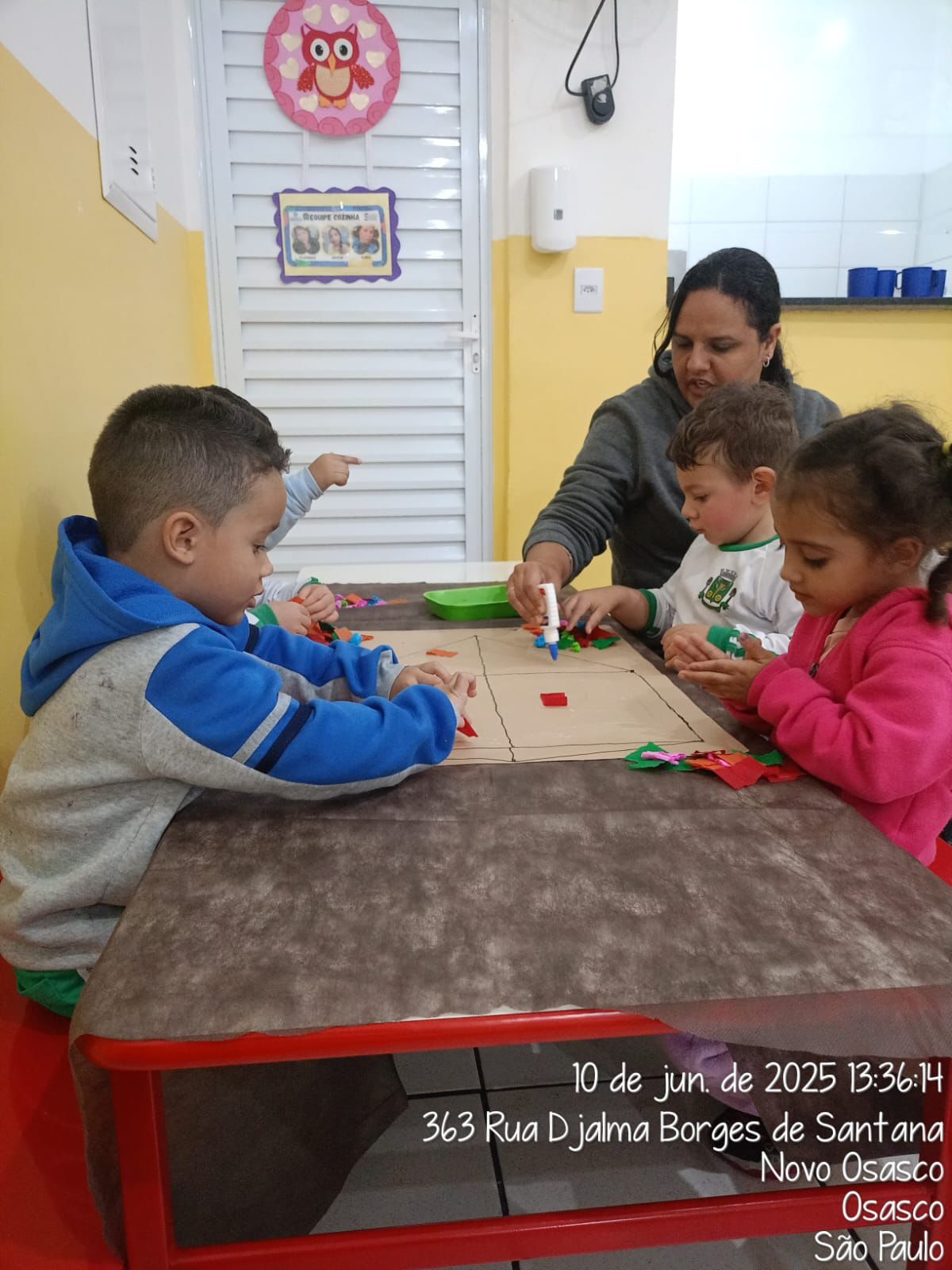 Crianças colando materiais durante atividade dirigida
